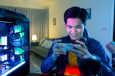 asian cyber sport gamer have live stream and playing mobile game on the smartphone at home