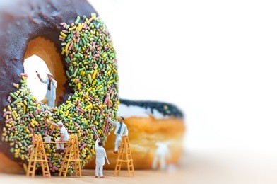 group of painters painting over huge donut. macro photo