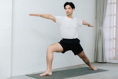 asian young man doing yoga at home