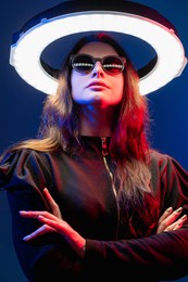 future girl. cyberpunk portrait. science fiction. galaxy portal. red neon light futuristic female alien in sunglasses with white led circle halo illumination isolated on dark blue.