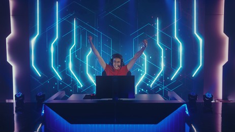 professional esports gamer playing in computer video games, happily and cheerfully celebrates victory and success. online cyber championship  tournament. portrait front view shot