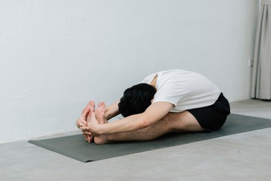 asian young man doing yoga at home