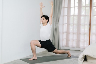 asian young man doing yoga at home