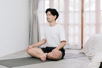 asian young man doing yoga at home