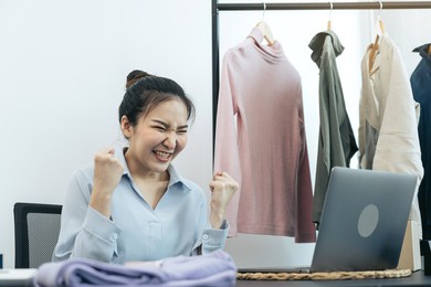 young asian entrepreneurs are excited about hitting today's clothing sales target.