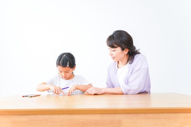 girl studying with her mother at home