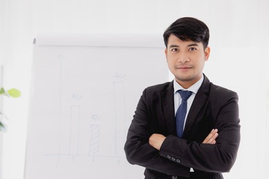 smart confident asian adult business man. office employee standing arm crossed looking camera.
