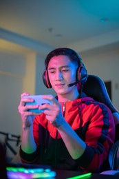 asian man have live stream and playing mobile game on the smartphone at home