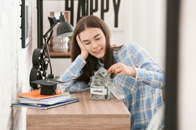 teenage girl with savings for education at home