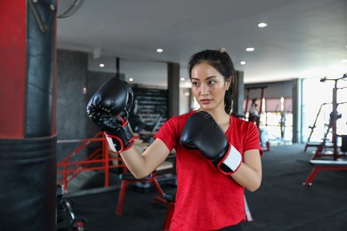 beautiful women asian boxer happy and fun fitness boxing and punching a bag with wearing boxing gloves. 