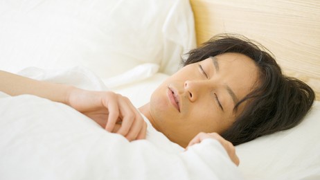 asian man sleeping in bed