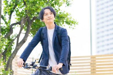 young asian man riding a bicycle.