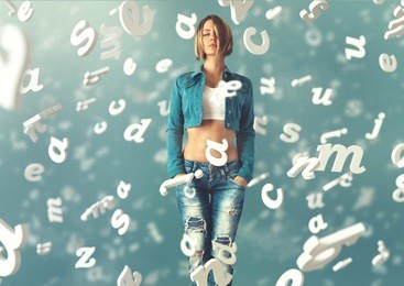 sexy young woman in a trendy clothes with letters flying arround her