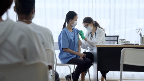 people queuing up for vaccination against the epidemic. people get vaccine injection from nurse in hospital medical room. doctor make a vaccine injection to people for antibody.