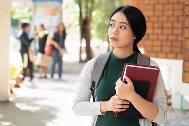 female student getting back to school after vaccination but still keeping precautious social distancing