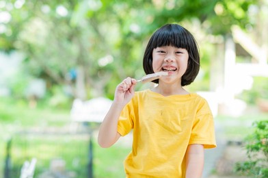 asian girl eating ice cream with blur background