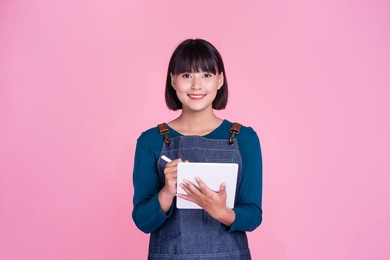 barista waitress using smart tablet tech taking orders customer service café shop asian woman start up small business owner employee worker entrepreneur occupation apron pink isolated background
