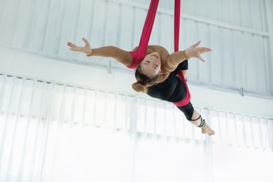asian beautiful woman doing aerial dance practice in hammock at studio, asian women perform dances using a hammock in the dance