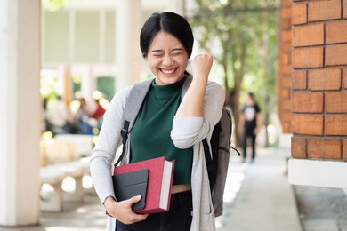 excitted and confident asian woman college student getting back to school after reopening and vaccination rollout program