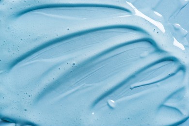 gel texture on blue background close up. strokes of transparent gel cosmetic product.