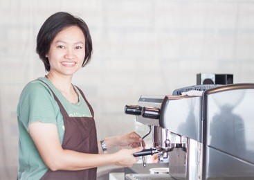asian barista smiling and making cup of coffee, stock photo