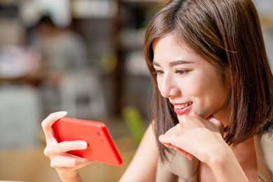 young woman watch video on mobile phone in coffee shop