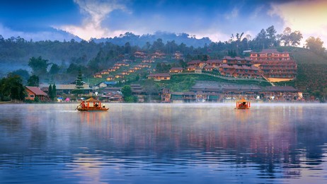 tourists take a boat at ban rak thai village in mae hong son province, thailand.