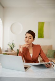 portrait of pretty cheerful accountant looking away sitting at desk in modern office