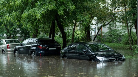 flooded cars on the street of the city. street after heavy rain. water could enter the engine, transmission parts or other places. disaster motor vehicle insurance claim themed. severe weather concept