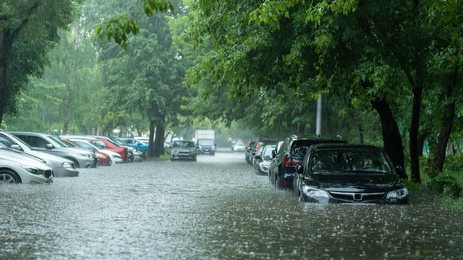 flooded cars on the street of the city. street after heavy rain. water could enter the engine, transmission parts or other places. disaster motor vehicle insurance claim themed. severe weather concept