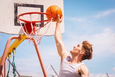 slam dunk. side view of young basketball player making slam dunk