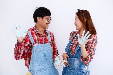 portrait young asian couple in yom-bear and plaids shirts painting a new color the room renovation concept 