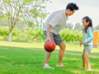 happy father and daughter are playing basketball in the park high quality photo
