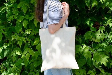 empty reusable canvas tote bag mockup. natural canvas eco-friendly shopper bag on girl's shoulder. mockup for presentation of design or brand