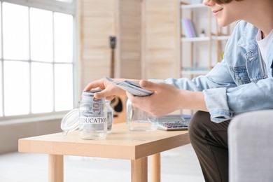 teenage boy with savings for education at home