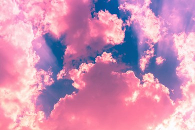 bright pink clouds in dark blue sky with sun beam light