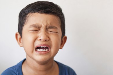 4 year old of toddler asian boy uncontrollable and bad behavior and show funny face and angry face at home. attention deficit hyperactivity disorder adhd, sad and cry sick bipolar disorder concept.