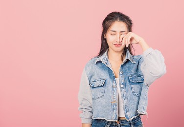 asian portrait beautiful cute young woman wear denim bad mood her cry wipe tears with fingers, studio shot isolated on pink background, thai female feeling sad unhappy crying with copy space