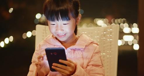 cute asian girl use smartphone at night