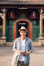 handsome man taking a photo on a trip in asia