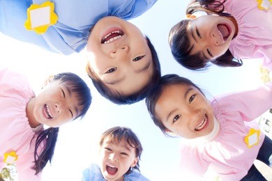 five kindergarten children laughing in a circle