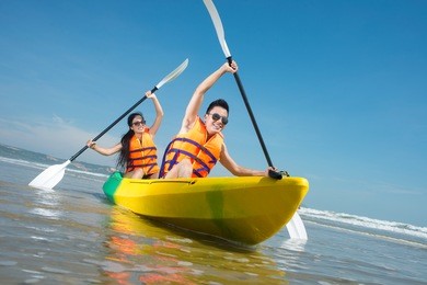 cheerful couple paddling in kayak