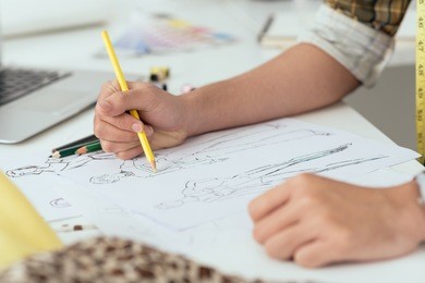 close-up of designer drawing a fashion sketch