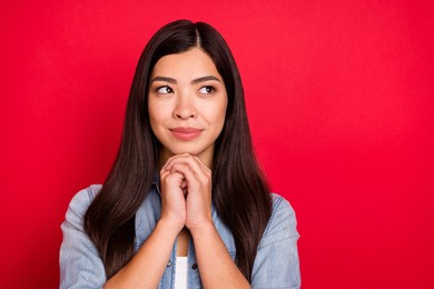 portrait of attractive minded girl thinking copy empty space dilemma isolated over bright red color background