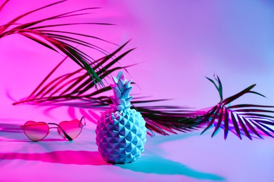ceramic pineapple with sunglasses and tropical leaf on dark color background
