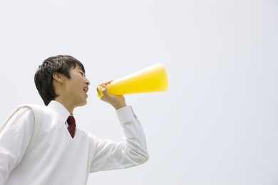 a middle school boy screaming through a megaphone