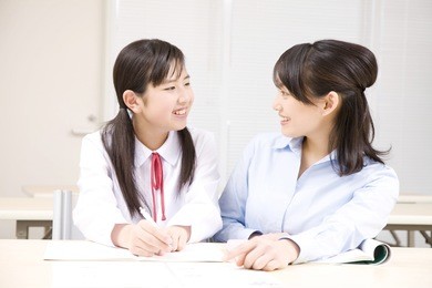 a middle school girl learning from a teacher at an institute