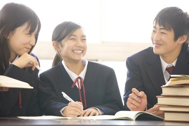 middle school boys and girls studying in a library
