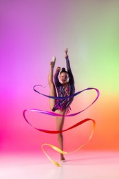 ribbon exercises. young beautiful graceful girl, female rhythmic gymnast training isolated over white studio background. concept of action, motion, sport life, competition. front view