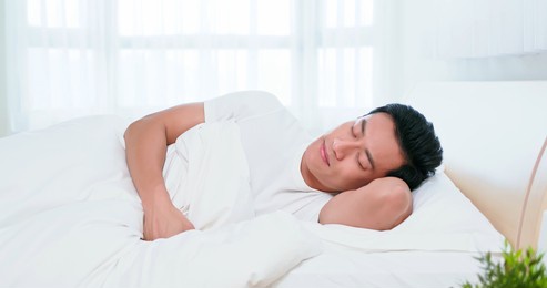 asian man sleep well on bed in the morning at home